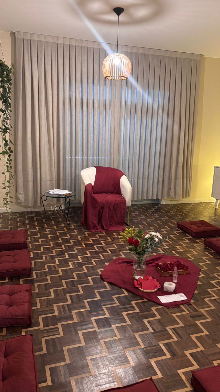 Sala preparada para vivência terapêutica em grupo com almofadas e altar central